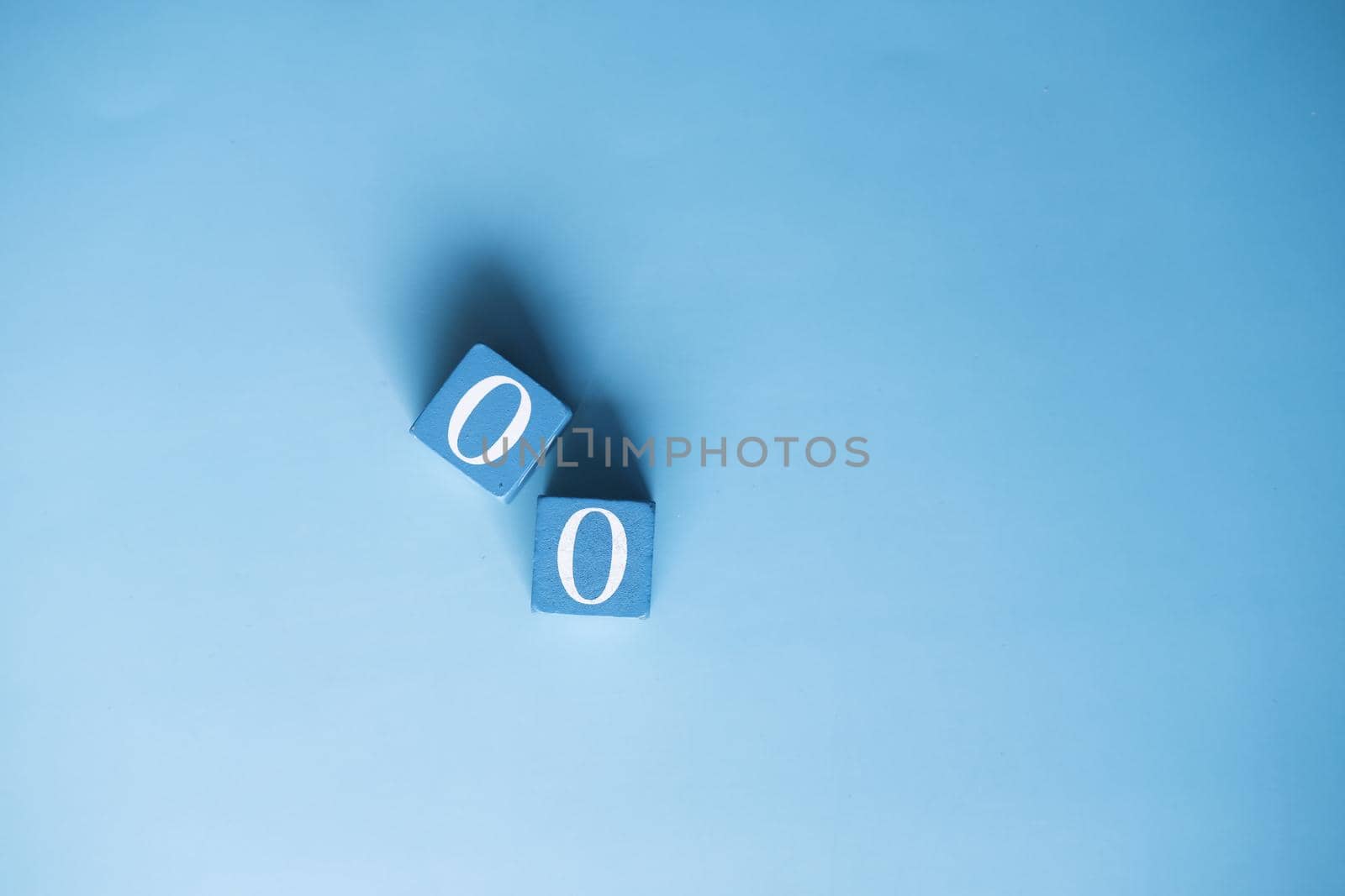number zero on wooden block on blue background .