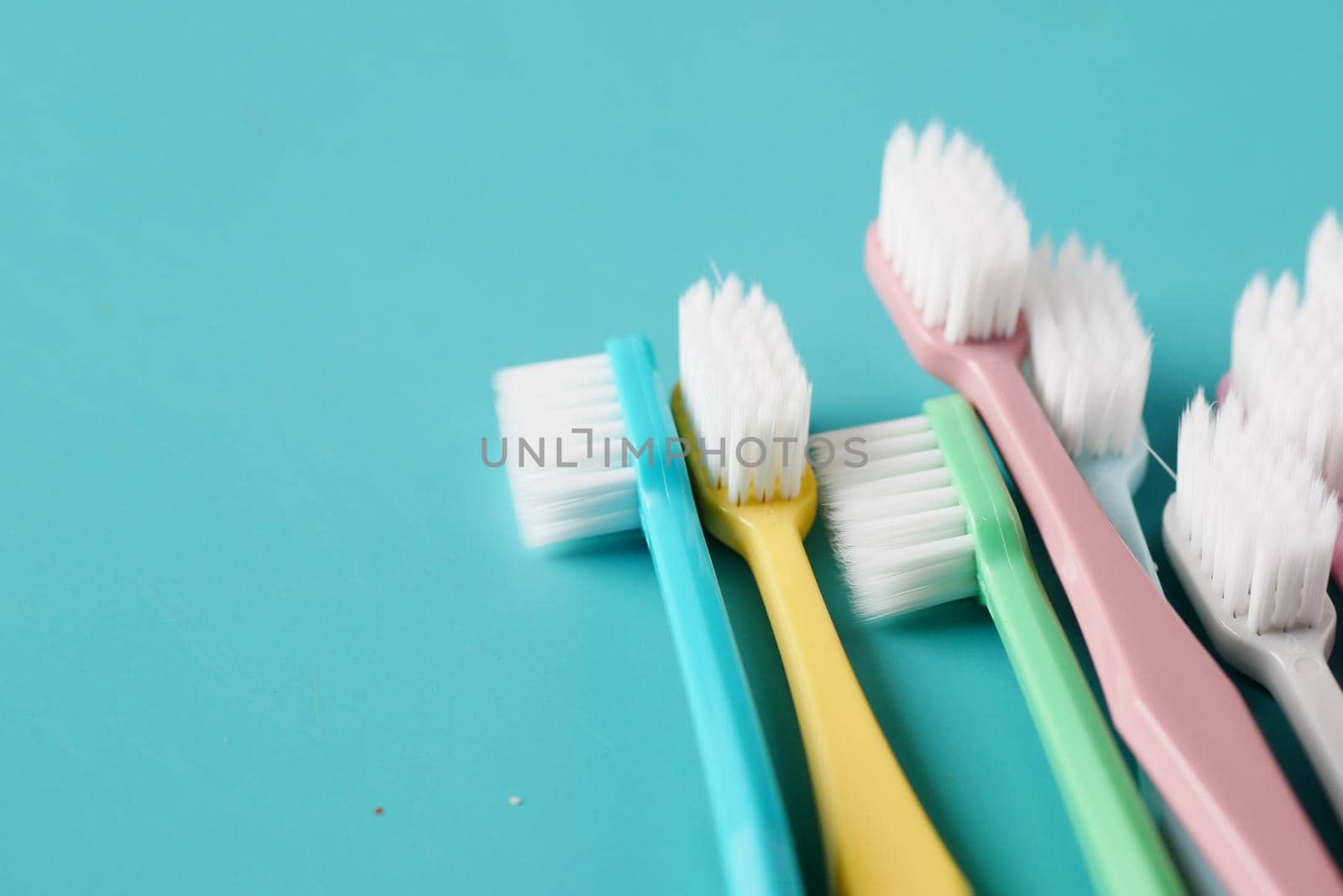 colorful toothbrushes on light green background .