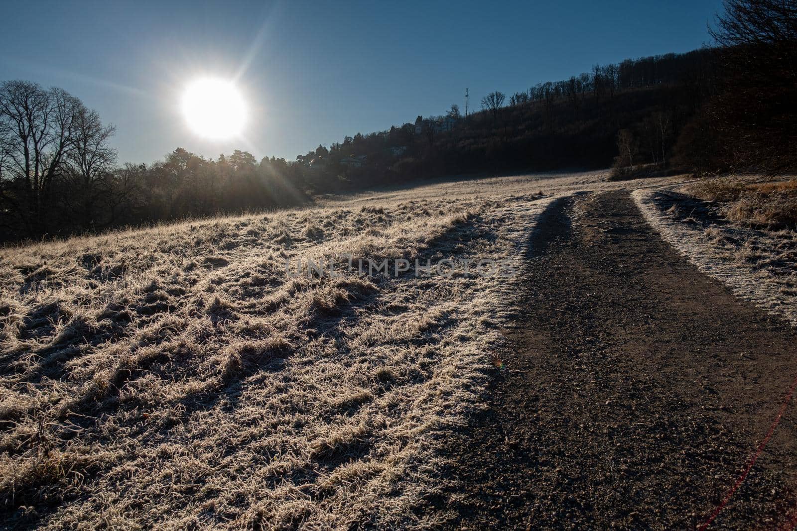 The sun is rising over a landscape marked by the morning frost.