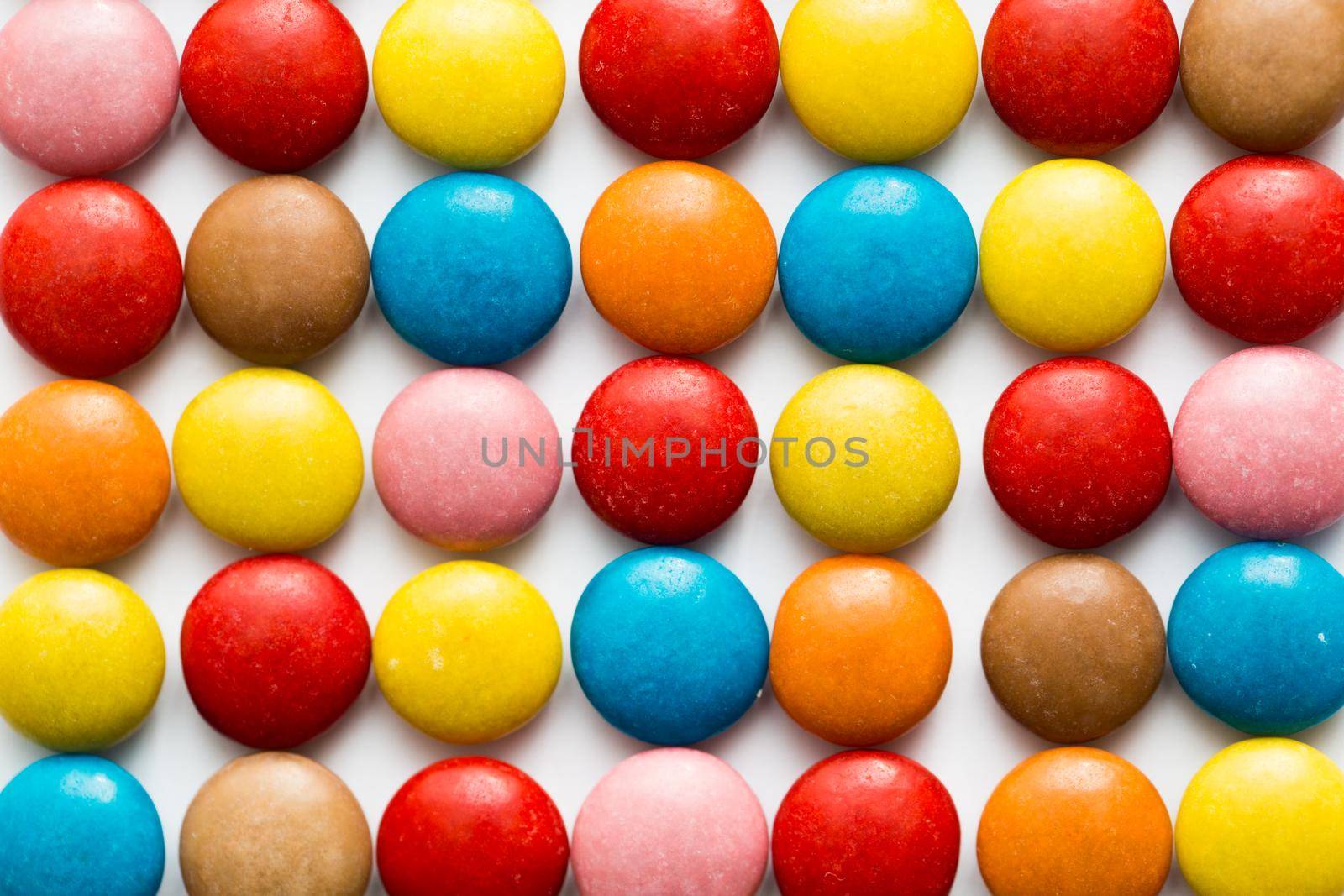 Close up of a pile of colorful chocolate coated candy, chocolate pattern, chocolate background. by StudioPeace