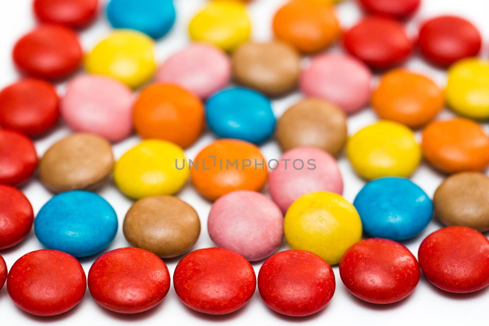 Close up of a pile of colorful chocolate coated candy, chocolate pattern, chocolate background. by StudioPeace