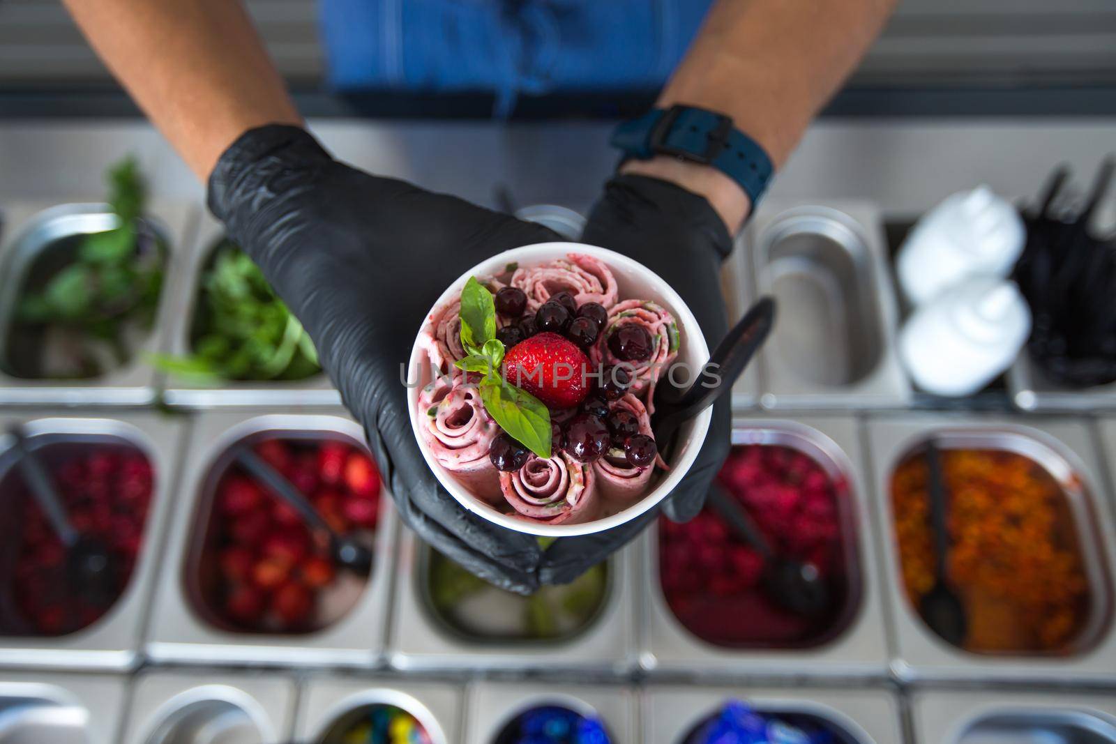 Stir-fried ice cream rolls at freeze pan. Rolled ice cream, hand made ice cream dessert. Fried ice cream machine with steel chilled pan by StudioPeace