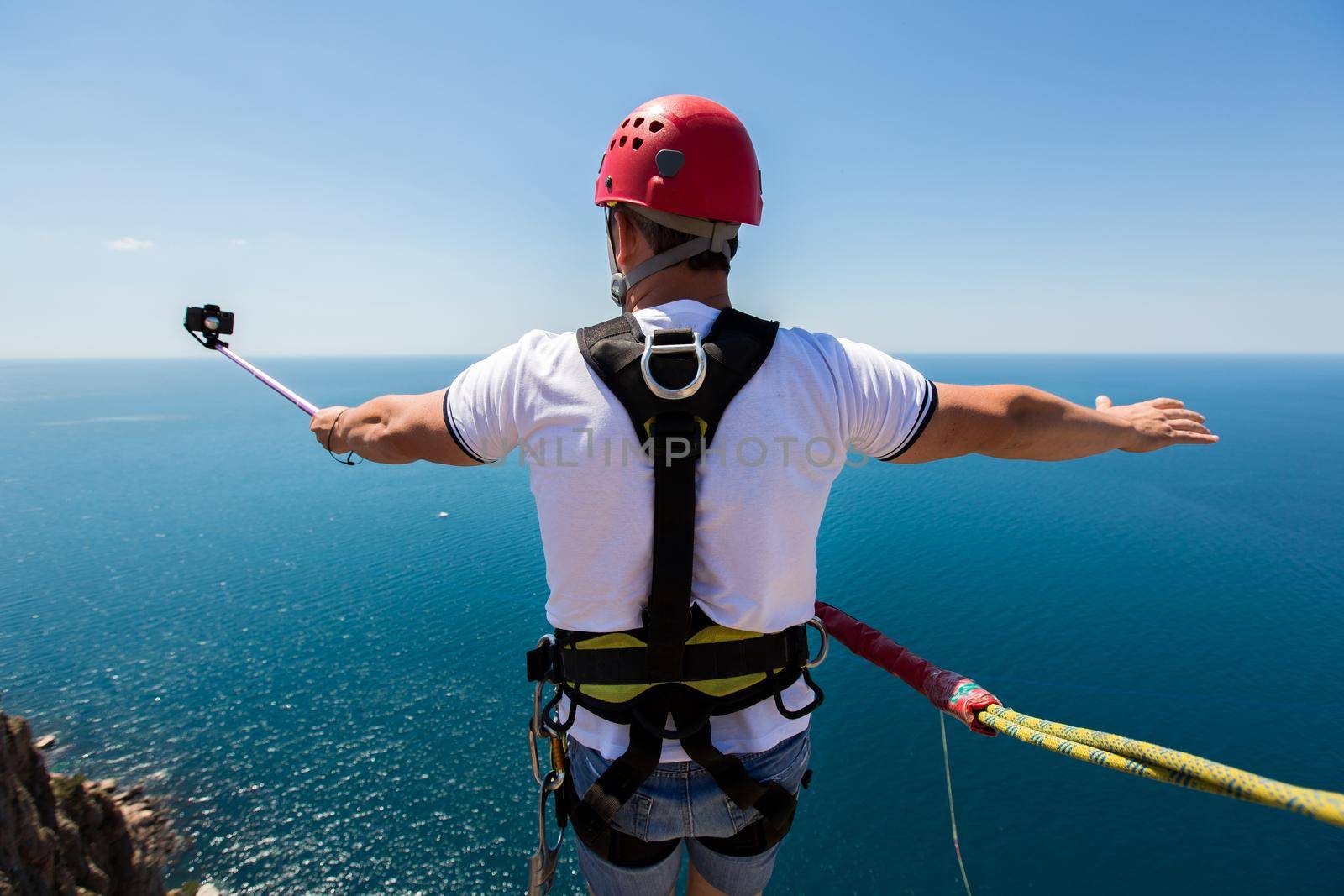 Rope jumping off a cliff with a rope in the water. The ocean. Sea. Mountain. by StudioPeace