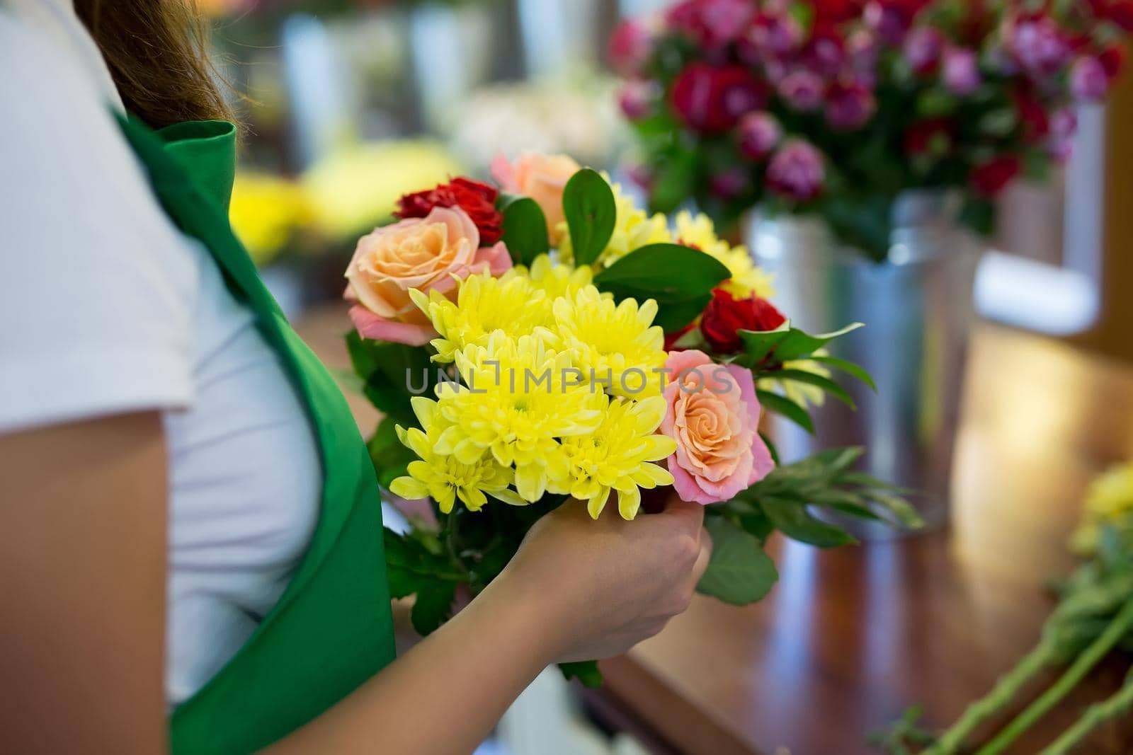 Workshop florist, making bouquets and flower arrangements. Woman collecting a bouquet of flowers