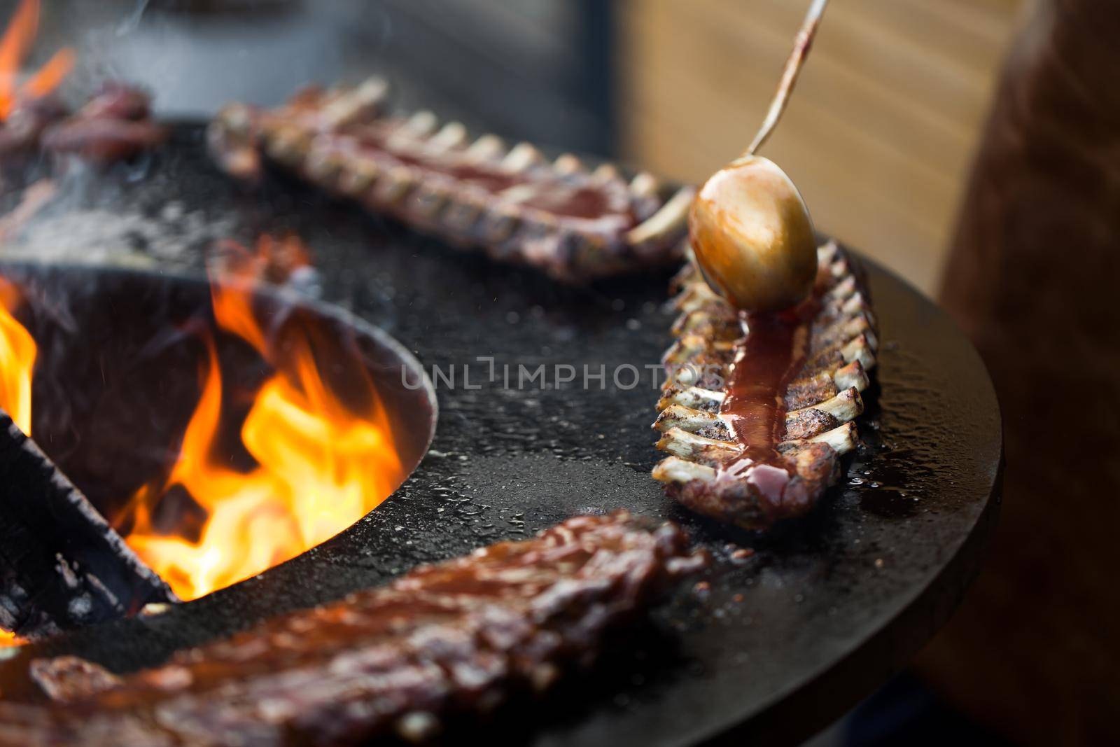 Grilled pork baby ribs with barbecue sauce on the grill. Festival street food. by StudioPeace