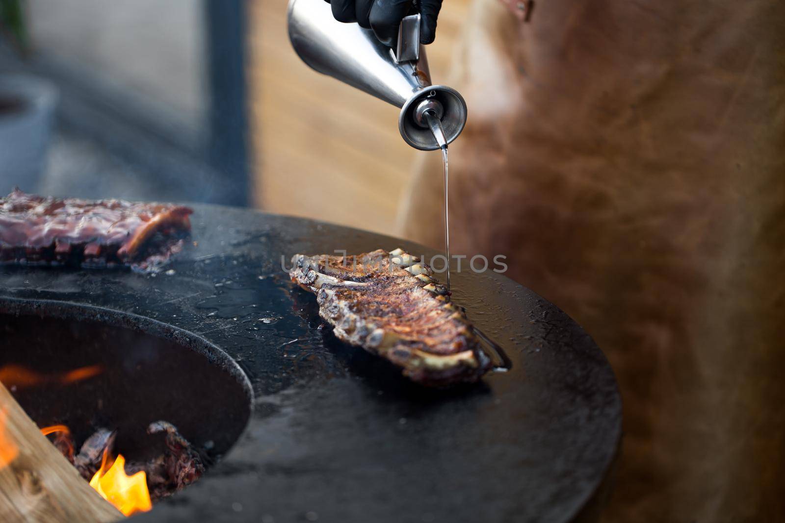 Grilled pork baby ribs with barbecue sauce on the grill. Festival street food. by StudioPeace