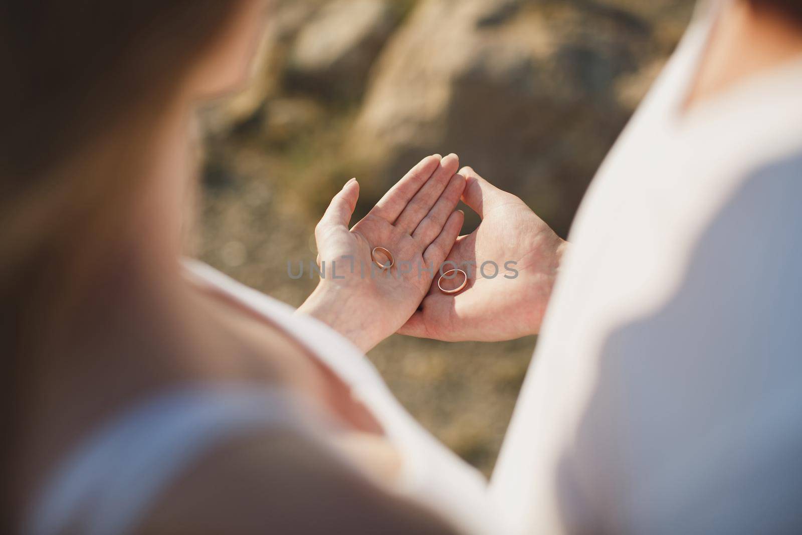 Bride's and groom's hand with wedding rings on the palms. by StudioPeace