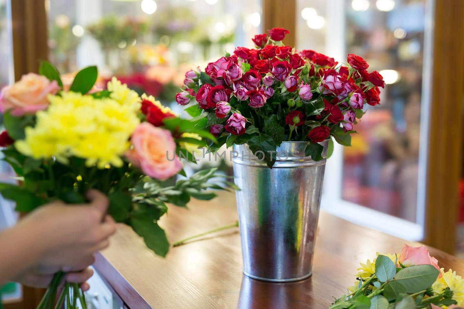 Workshop florist, making bouquets and flower arrangements. Woman collecting a bouquet of flowers. by StudioPeace