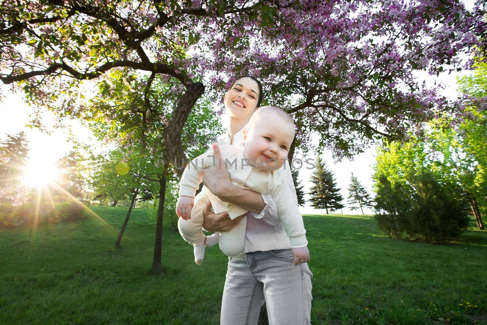 Beautiful Mother And Baby outdoors. Nature. Beauty Mum and her Child playing in Park