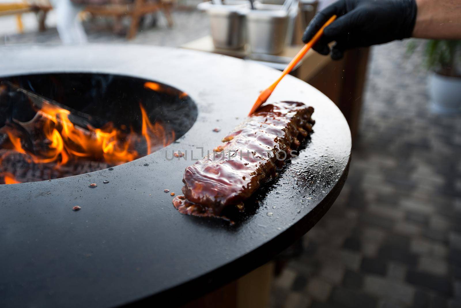 Grilled pork baby ribs with barbecue sauce on the grill. Festival street food