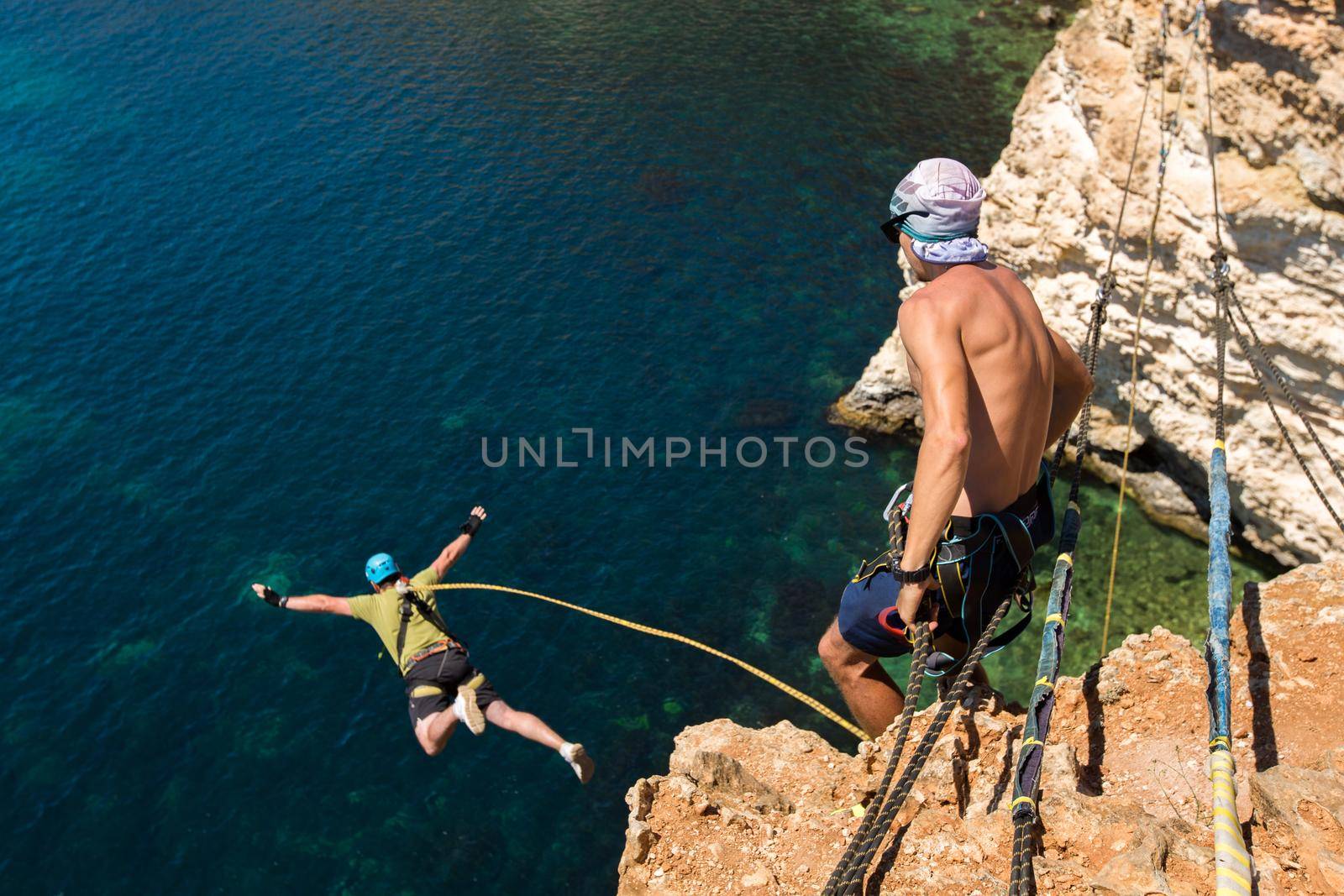 Rope jumping off a cliff with a rope in the water. The ocean. Sea. Mountain by StudioPeace