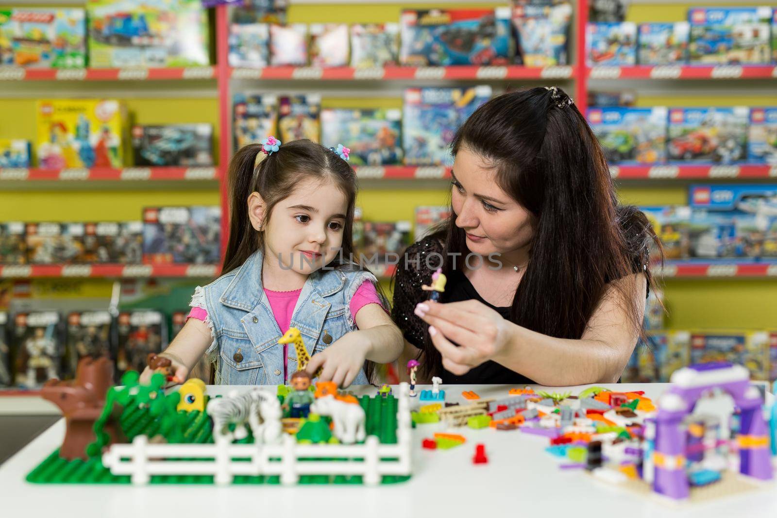 Mother with a little daughter playing with blocks