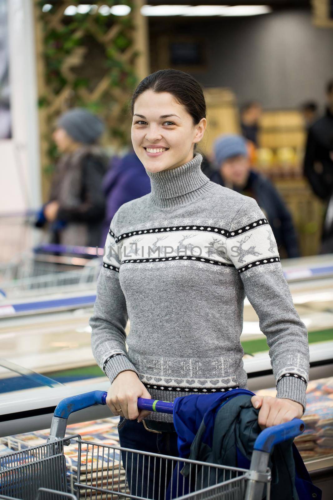 A young woman shopping in a supermarket. by StudioPeace