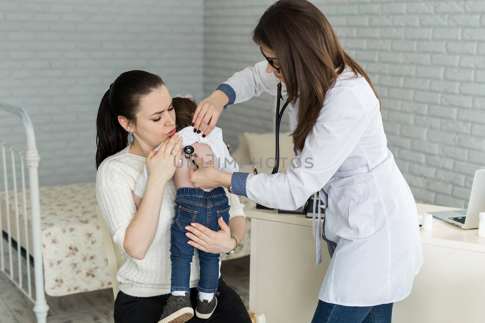 Professional general medical pediatrician doctor in white uniform gown listen lung and heart sound of child patient with stethoscope: Physician check up kid female after consult in hospital. by StudioPeace