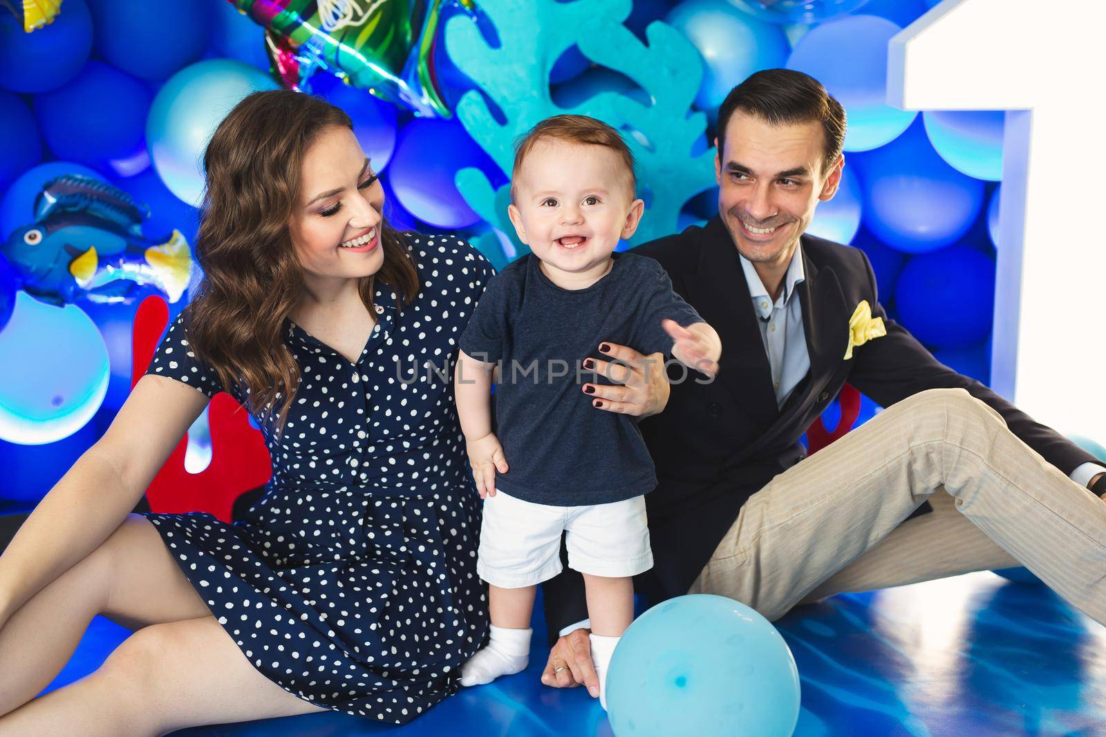Father, mother and son on the background of blue decor in the marine style at the holiday.
