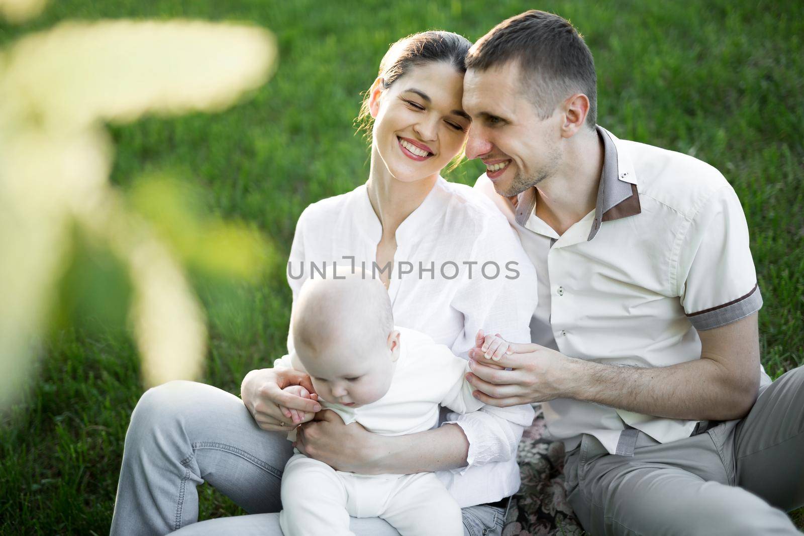 Portrait Beautiful Mother, Father And Baby outdoors. Happy family on a summer meadow. by StudioPeace