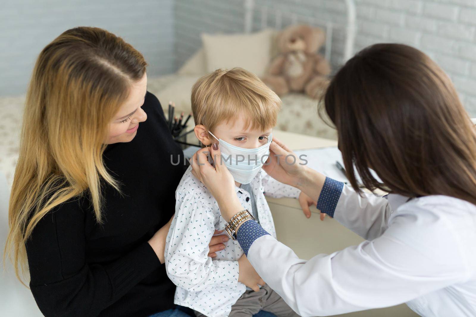 A boy in a medical mask at a doctor's appointment