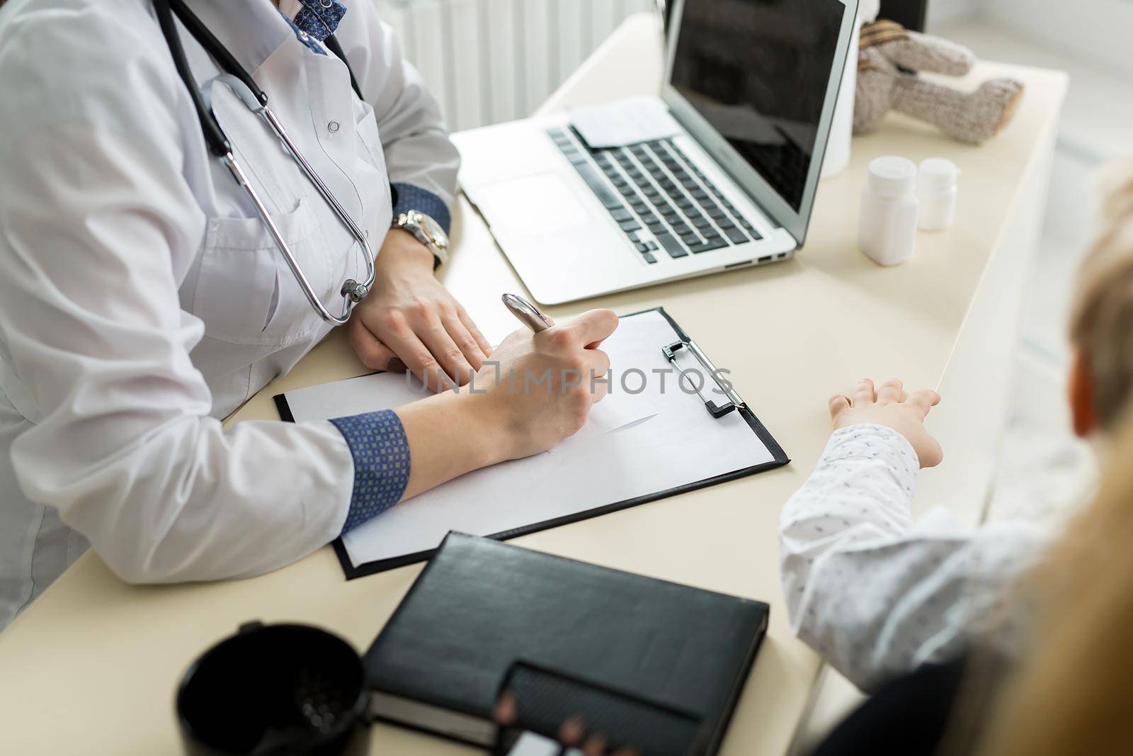 Close-up Of Female Doctor Filling The Medical Form