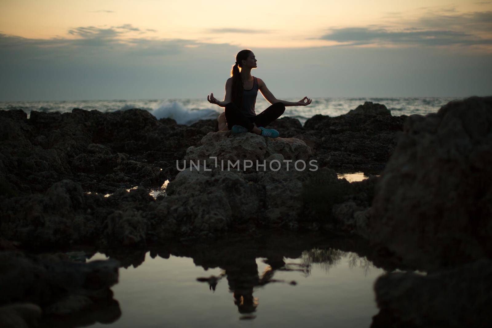 Caucasian woman practicing yoga at seashore of ocean