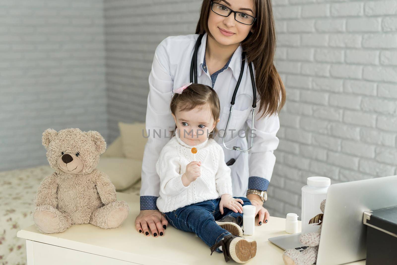 Doctor examining a little girl in a hospital. by StudioPeace