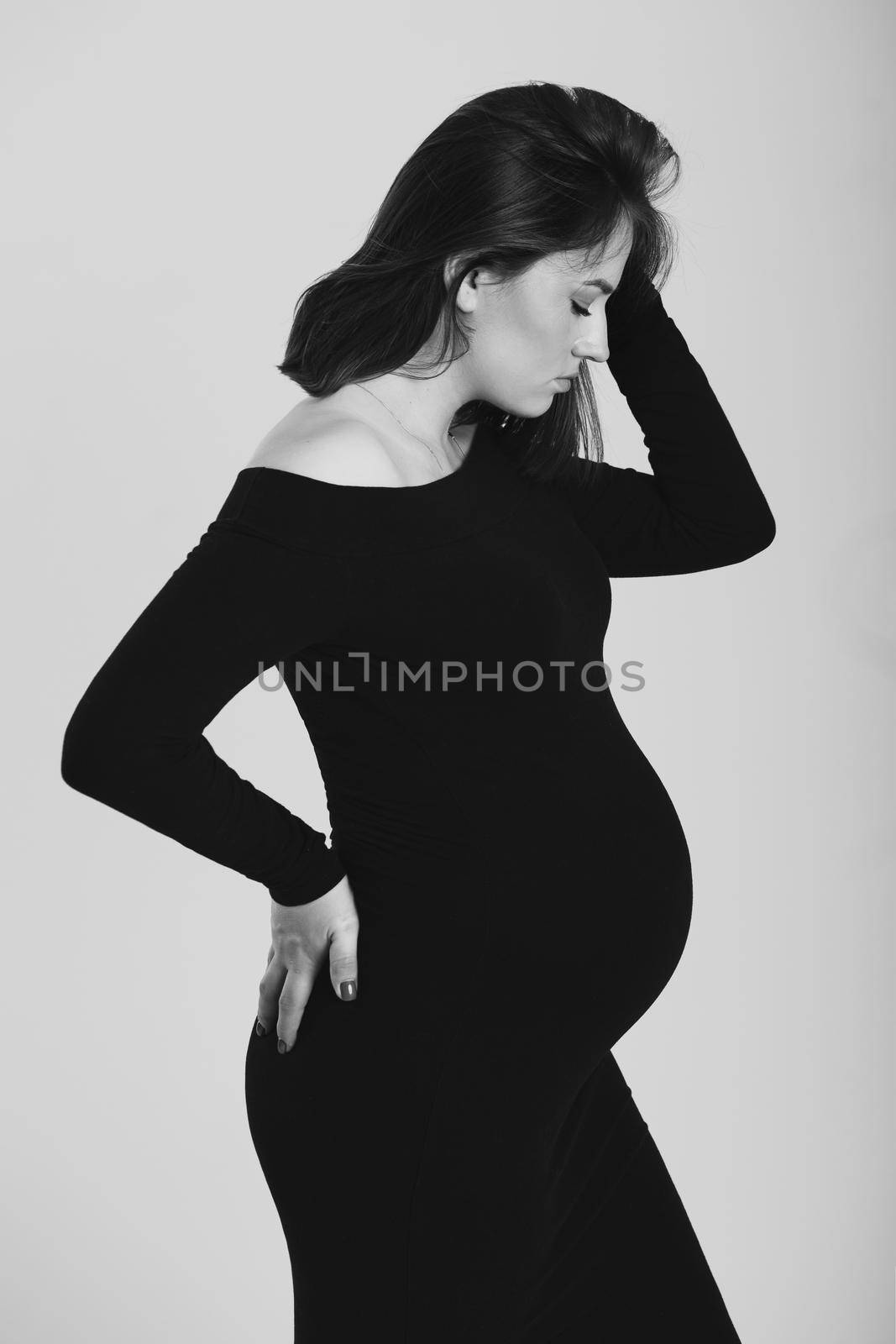 Black and white photo of a pregnant woman on a white background. Silhouette by StudioPeace