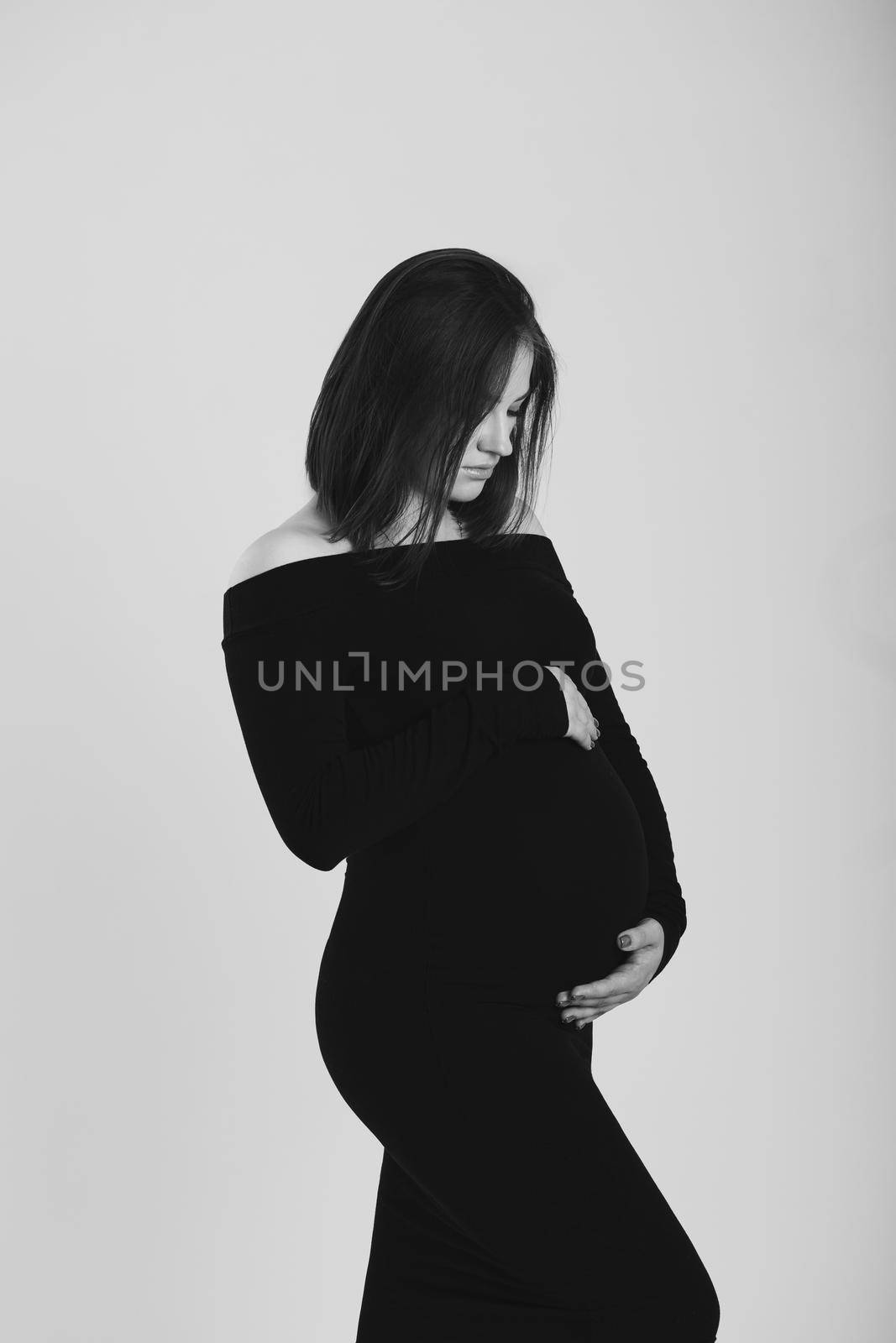 Black and white photo of a pregnant woman on a white background. Silhouette.