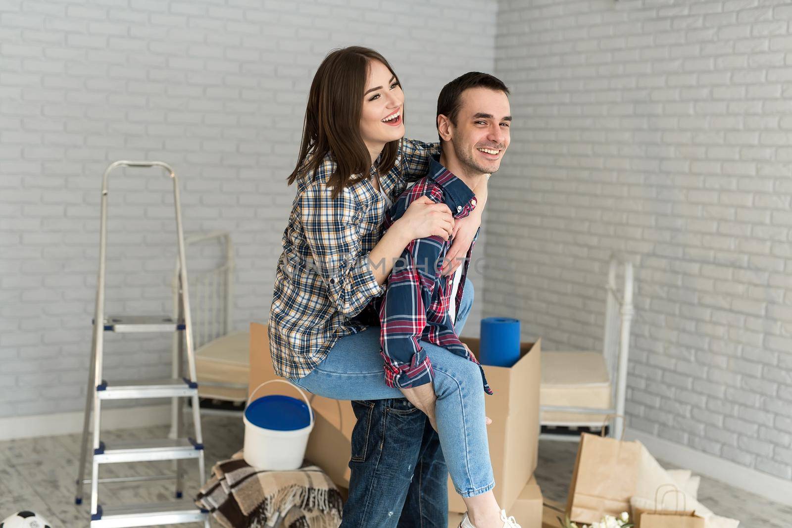 Happy couple is having fun in new house at moving day.