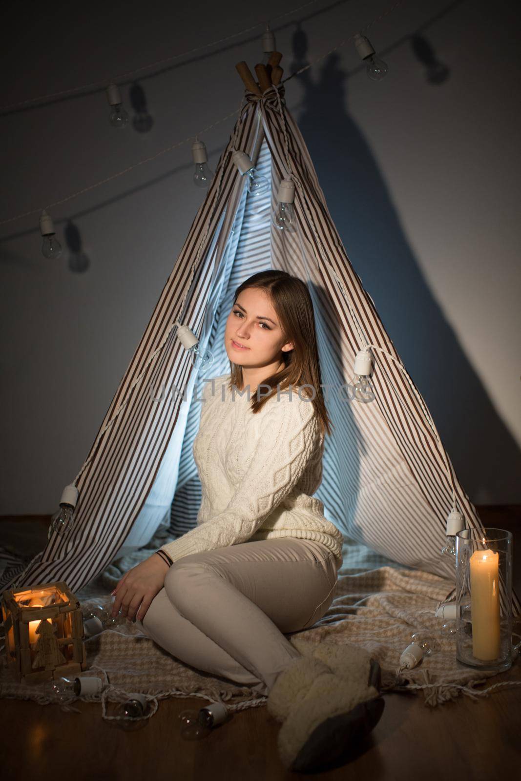 Beautiful girl on Christmas eve, sitting in a comfortable interior. New year