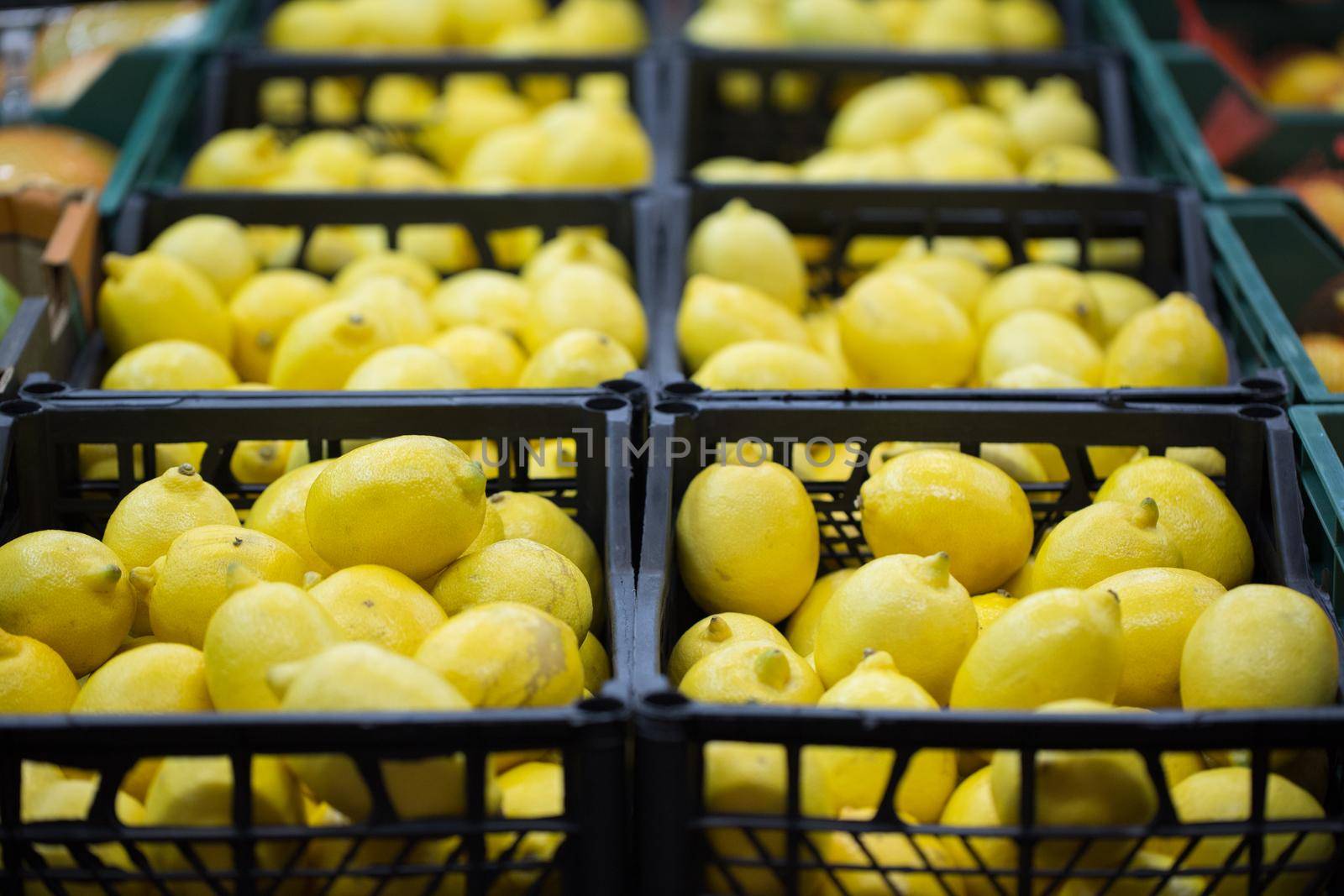 lemons are on display in boxes in the supermarket. by StudioPeace