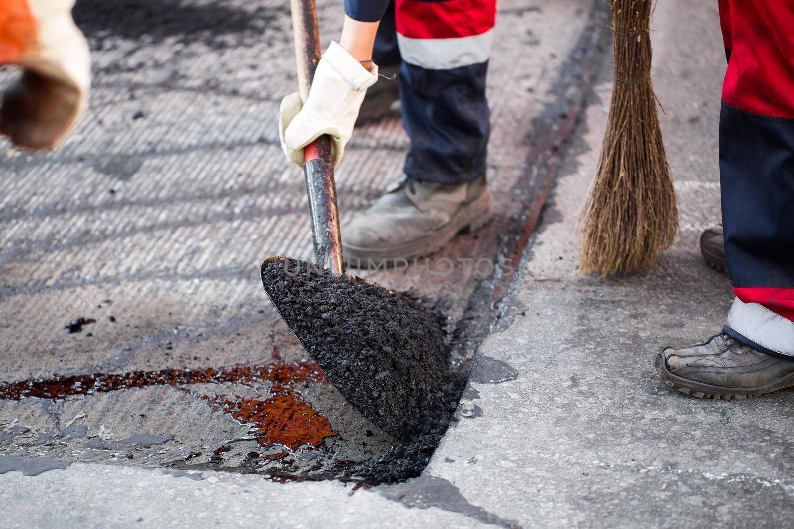 Young builder on Asphalting paver machine during Road street repairing works