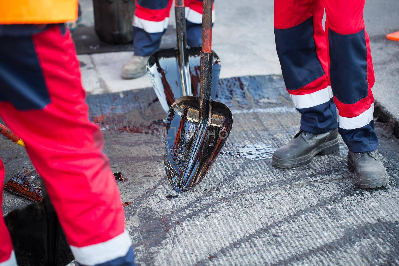 Repair of roads, highways and sidewalks. Patching. Working with a shovel falls asleep in the pit