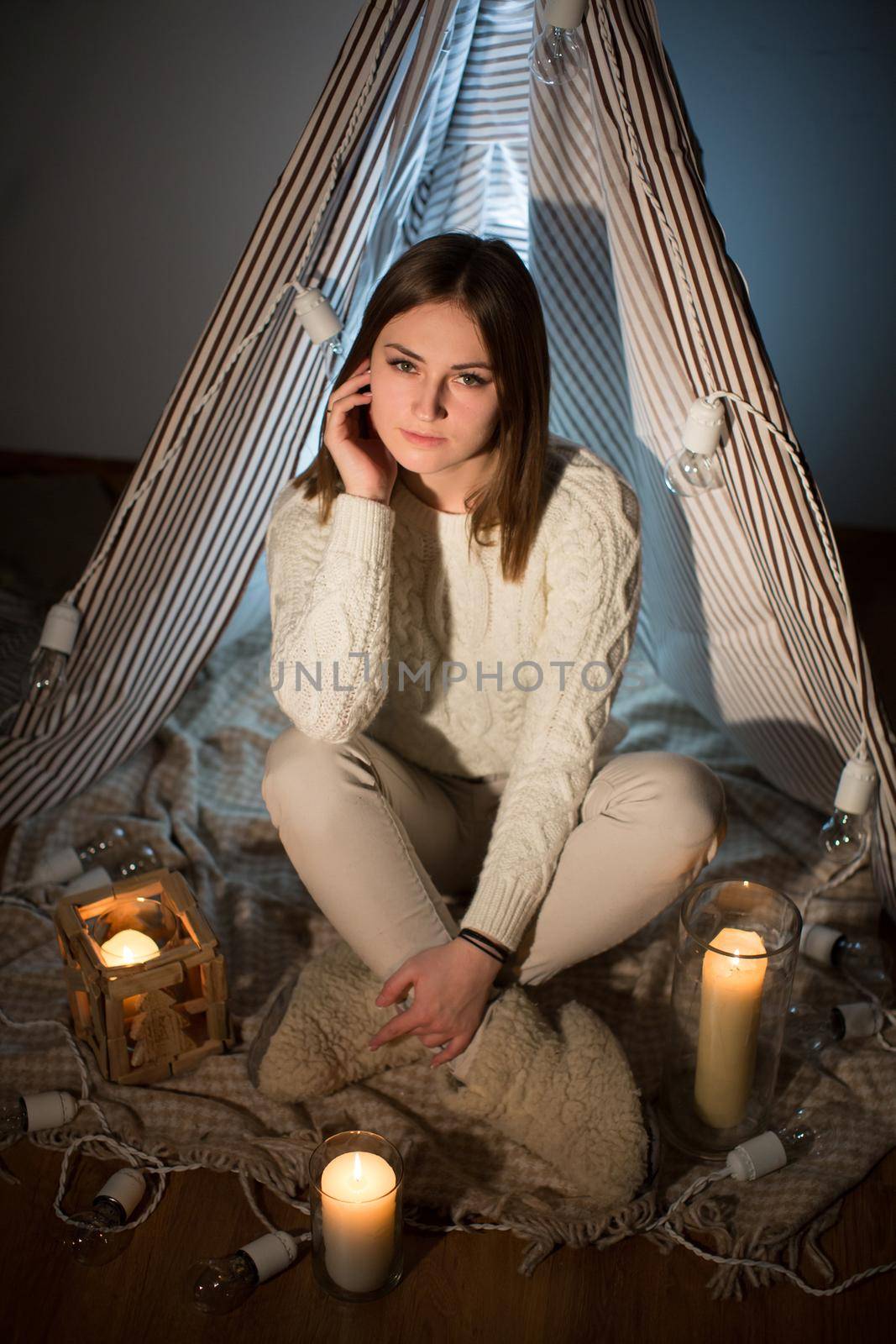 Beautiful girl on Christmas eve, sitting in a comfortable interior. New year