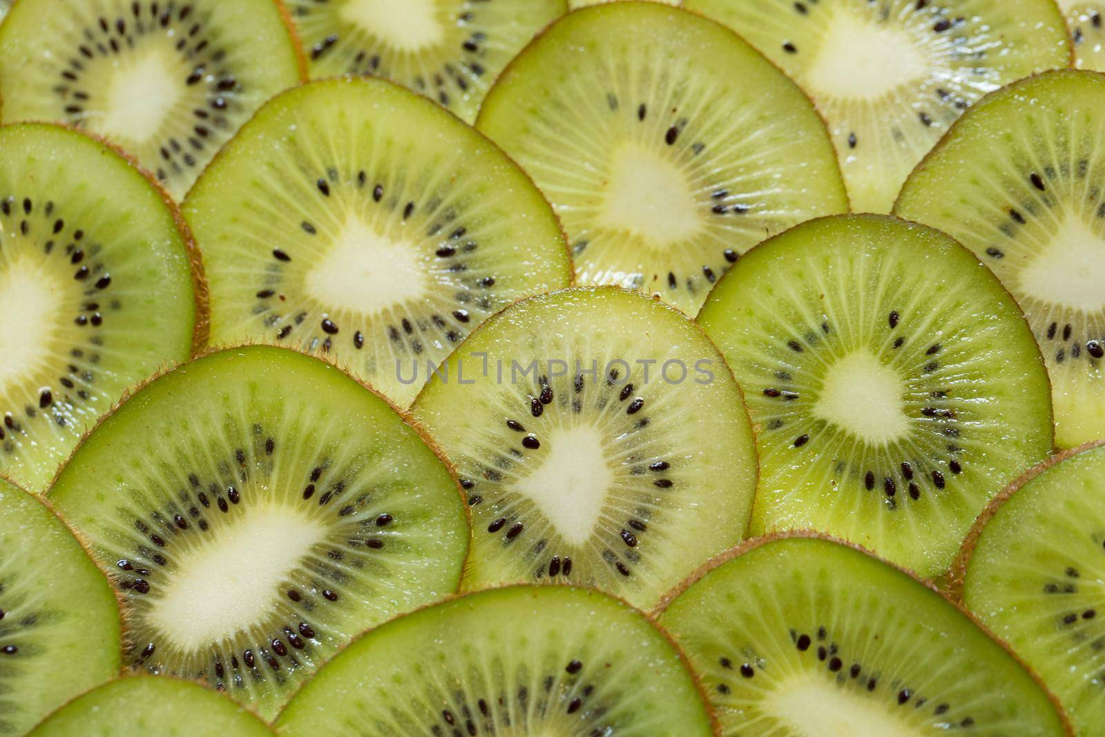 Bright green background with slices of juicy kiwi. Healthy food background by StudioPeace