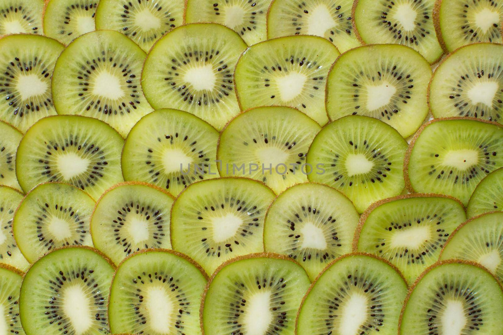 Bright green background with slices of juicy kiwi. Healthy food background by StudioPeace