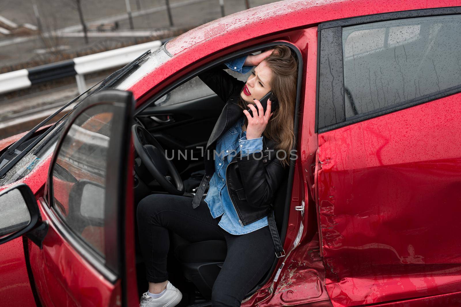 Young pretty scared woman in the car. Woman calls to a rescue service. by StudioPeace