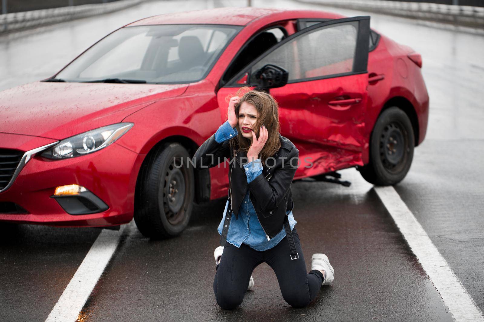 Woman sitting on the road after an accident. Injured woman feeling bad after having a car crash