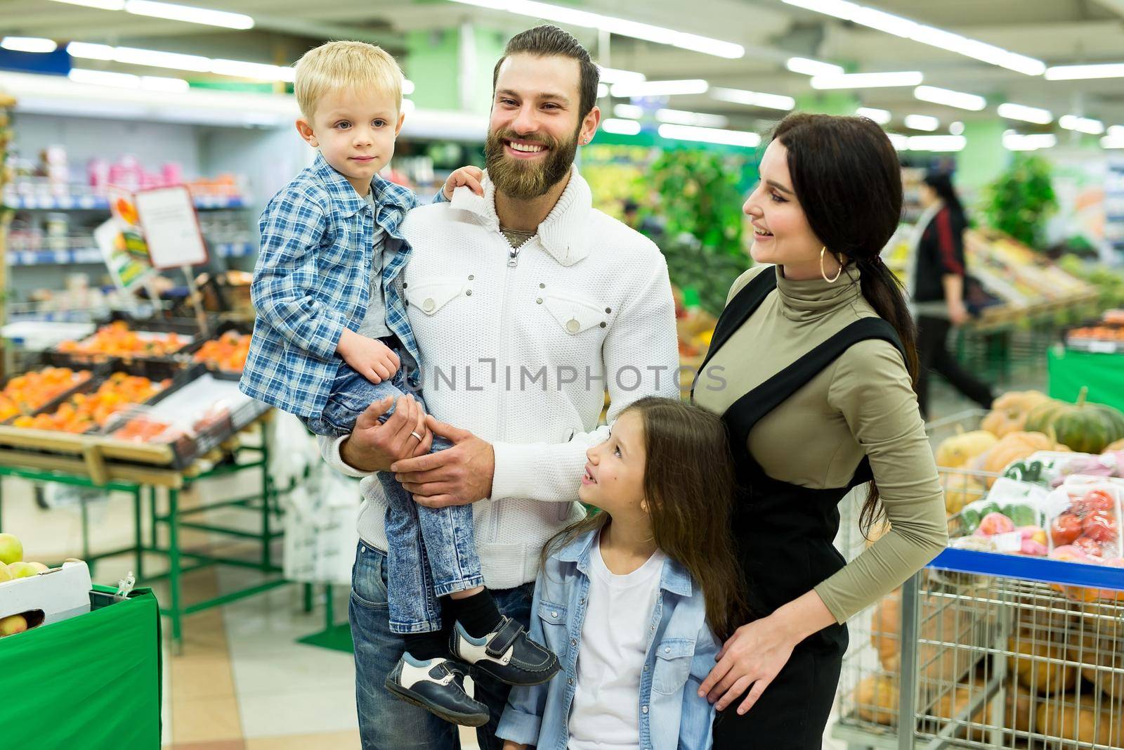 Portrait of a young family with a son and daughter in a supermarket by StudioPeace