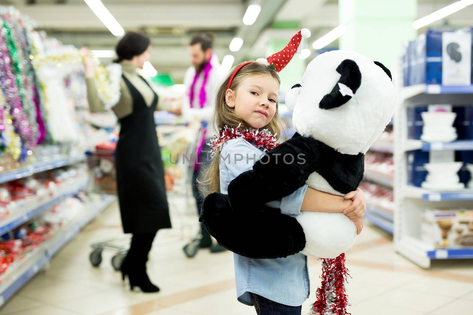 Happy young family in the supermarket chooses gifts for the new year