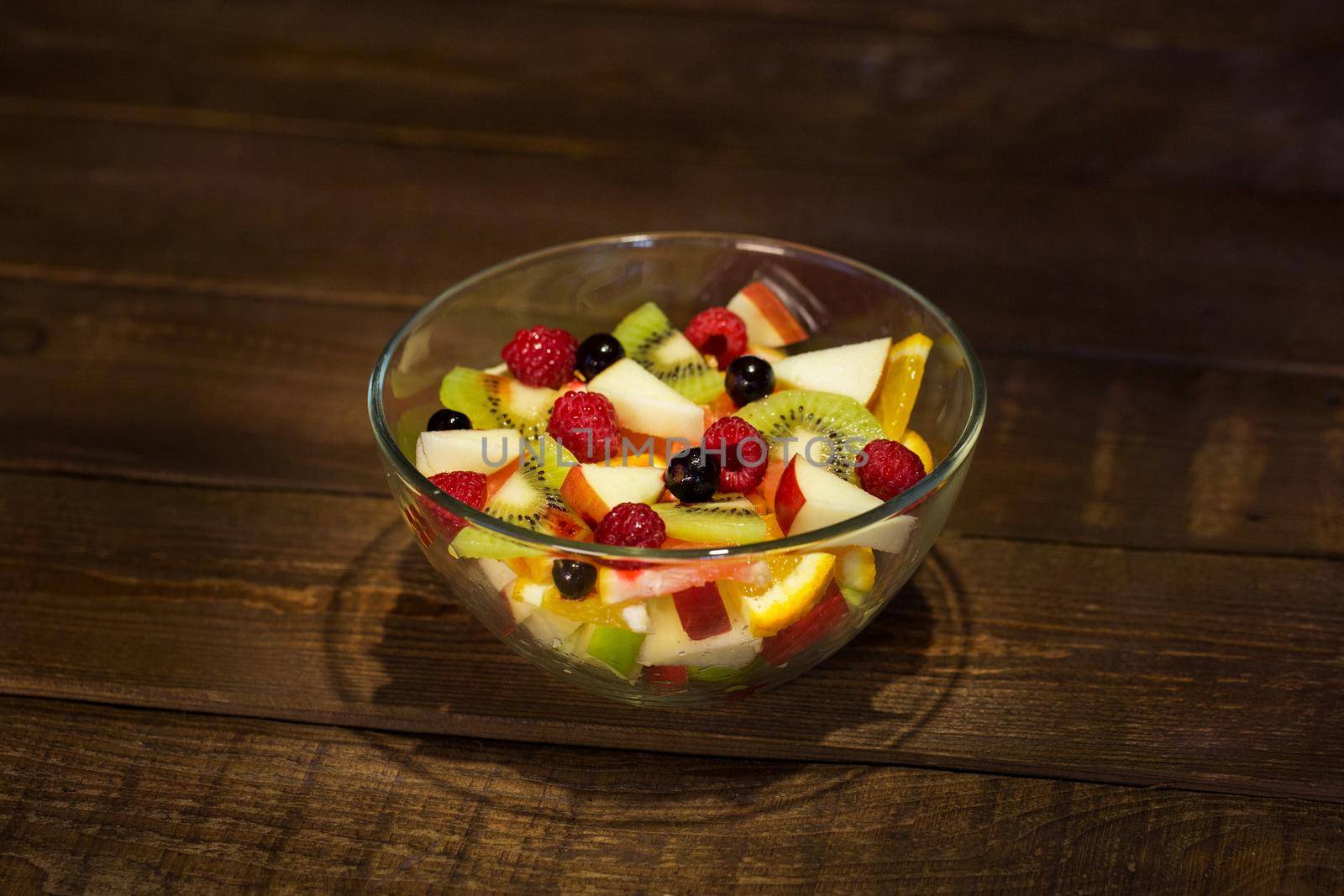 Delicious fruits salad in plate on table close-up. by StudioPeace