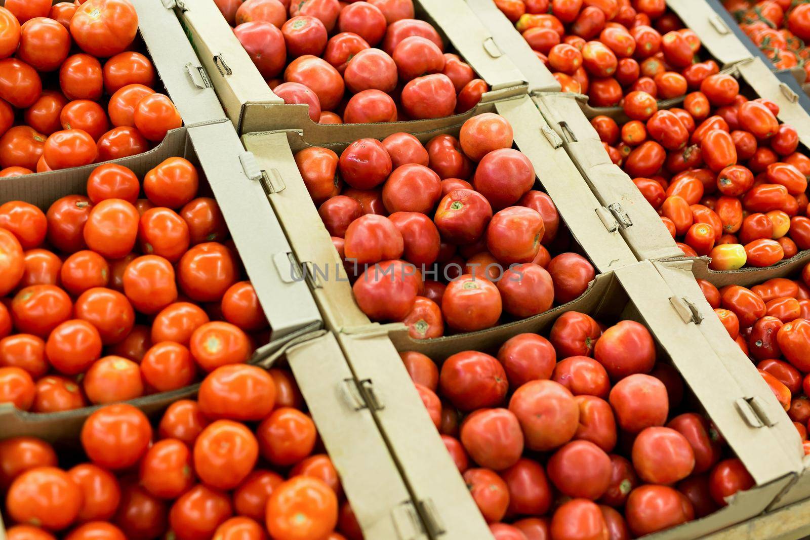 Fresh red tomatoes in boxes in the supermarket. by StudioPeace