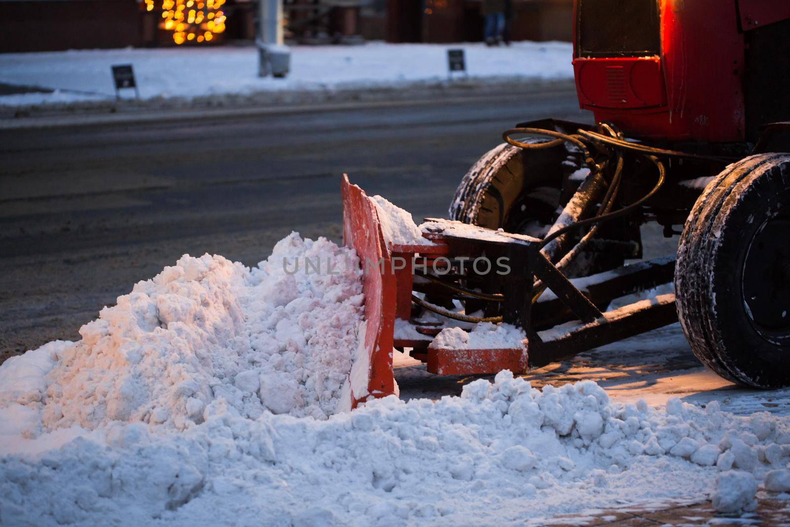 Tractor cleaning the road from the snow. Excavator cleans the streets of large amounts of snow in city by StudioPeace