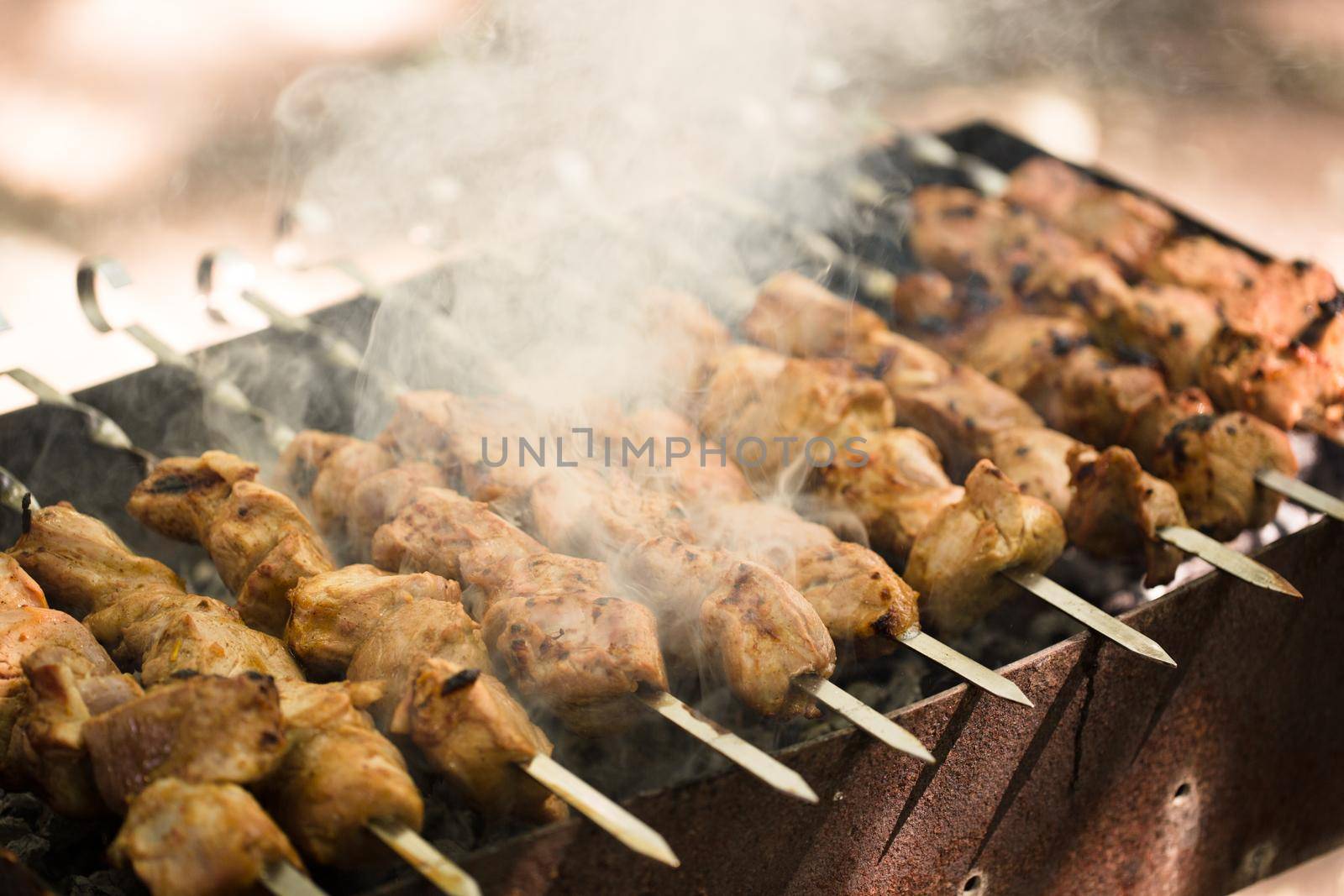 Marinated shashlik preparing on a barbecue grill over charcoal. Shashlik or Shish kebab popular in Eastern Europe. Shashlyk skewered meat was originally made of lamb. Roast Beef Kebabs On BBQ Grill