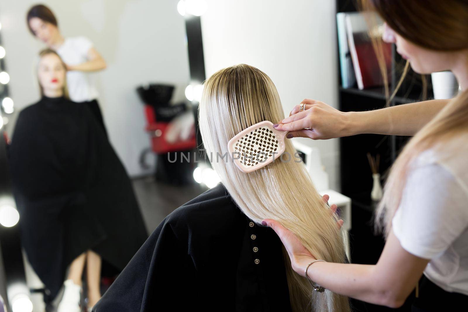 Comb hair. The master in the hairdresser prepares the client's girl to restore the procedures. by StudioPeace