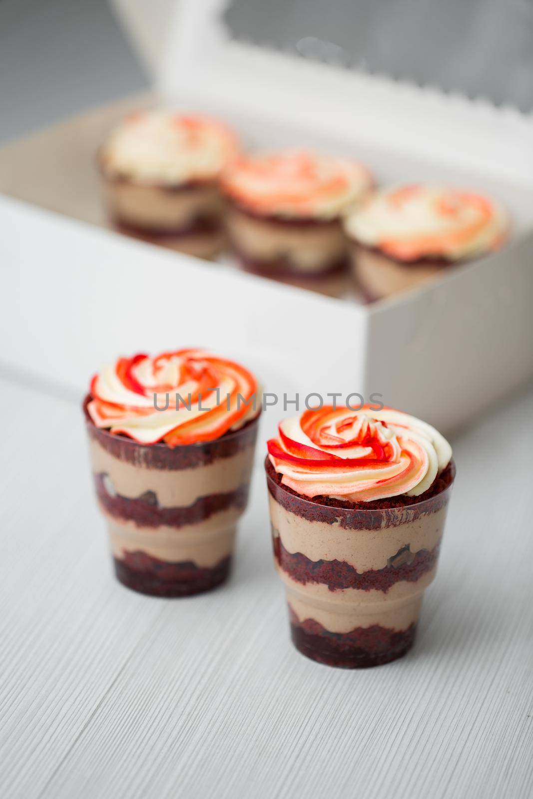 Chocolate and mousse trifle dessert in plastic cups by StudioPeace