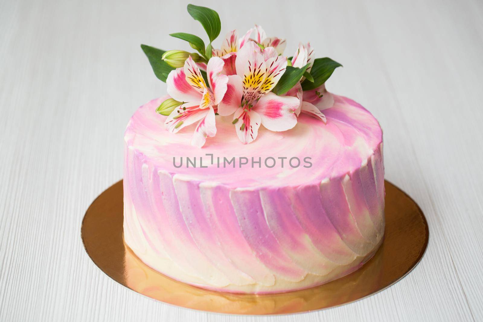 A cake with pink chocolate decor and flowers.