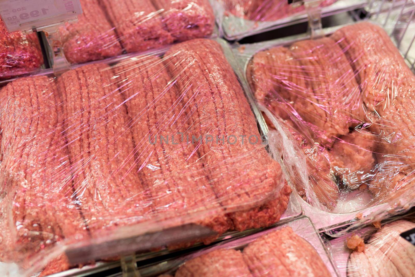 Various packages of beef or pork minced meat in the supermarket. by StudioPeace