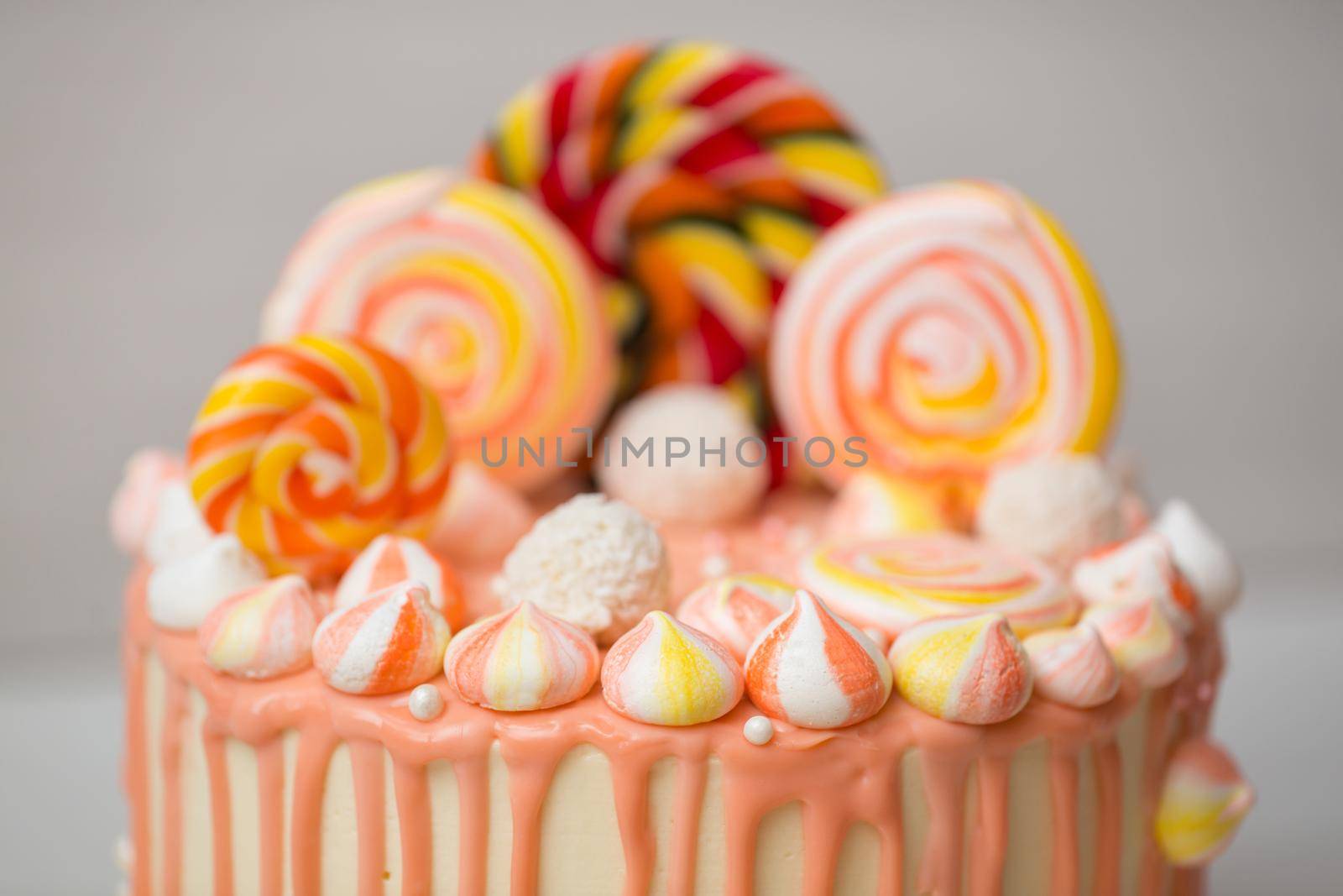 Peach colored cake with meringue and Candy for a child's birthday