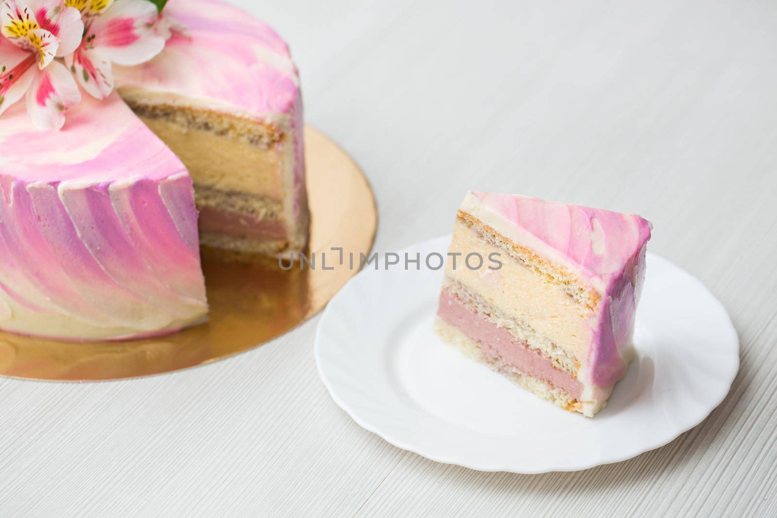 Cake with pink decor and flowers, cut massovogo cake