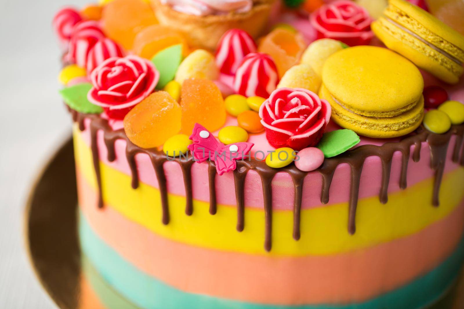 Colourful cake for a kid's birthday party with Lollipop, candy, marmalade, cupcakes and Bunny