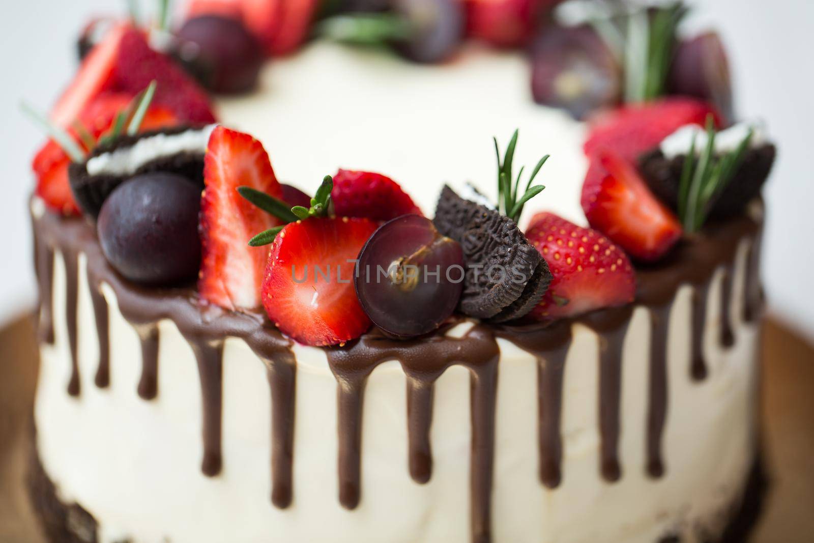 Cake with chocolate stains, strawberries, grapes, rosemary. by StudioPeace